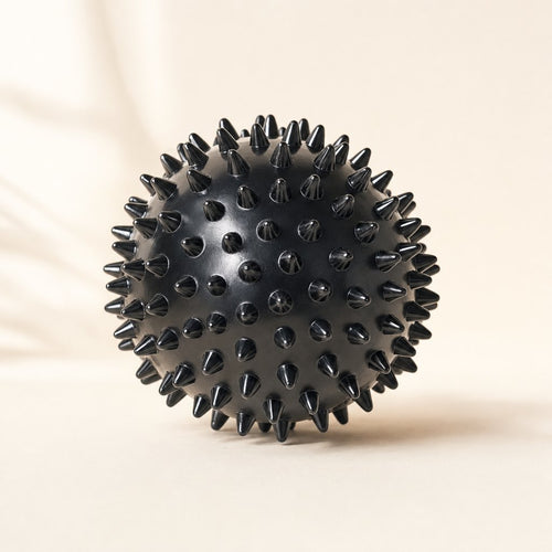 Black spiky massage ball, about 3 inches wide