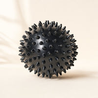 Black spiky massage ball, about 3 inches wide